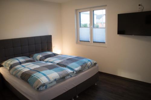 Schlafzimmer mit einem Bett und einem Flachbild-TV in der Unterkunft FEWO Klosterblick in Zeltingen-Rachtig
