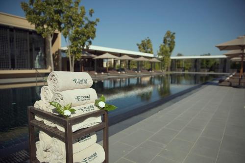a stack of towels next to a swimming pool at Emerald Palace Hotel in Nay Pyi Taw
