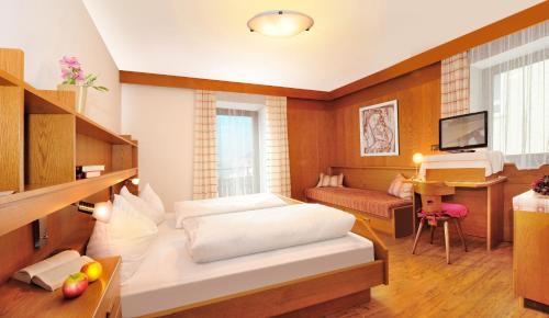 ナツ・シャーヴェスにあるGasthof Anichのベッドルーム1室(ベッド2台付)、リビングルームが備わります。