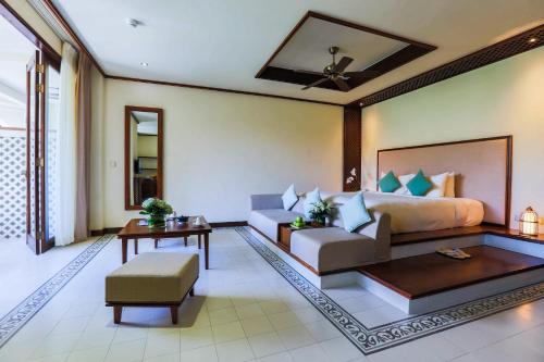 a living room with a bed and a couch at Almanity Hoi An Resort & Spa in Hoi An