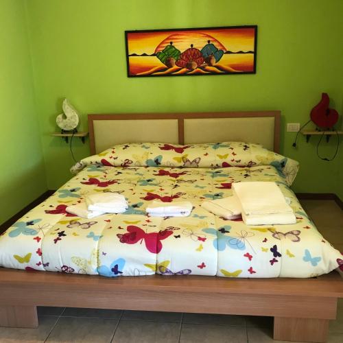 a bedroom with a bed with a bedspread with books on it at Butterfly House Bed & Breakfast in Alghero
