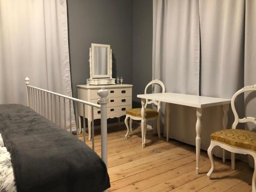 Skrunda Apartments Elandrum في سكروندا: غرفة نوم بسرير وطاولة وتلفزيون