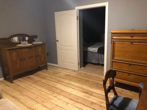 a room with a dresser and a bedroom with a bed at Skrunda Apartments Elandrum in Skrunda