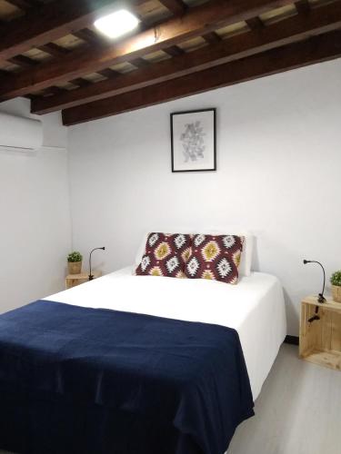 a bedroom with a bed with a blue blanket at CH Apartments in Conil de la Frontera