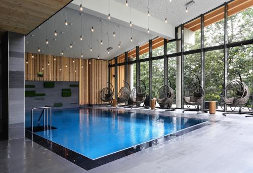 a swimming pool with chairs in a building at Konsumhotel am Park - Nebenhaus Berghotel Oberhof - nur Übernachtung in Oberhof