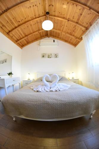 a bedroom with a large bed with a white bow on it at Suites & Spa Galilee in Qiryat Shemona