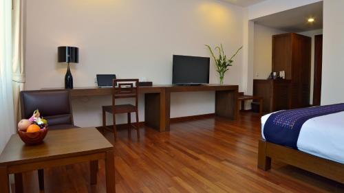 a hotel room with a bed and a desk with a computer at Emerald Palace Hotel in Nay Pyi Taw