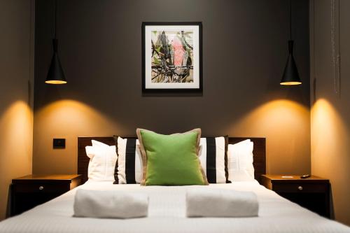 瑟爾的住宿－Criterion Hotel Sale，一间卧室配有一张带绿色枕头的床