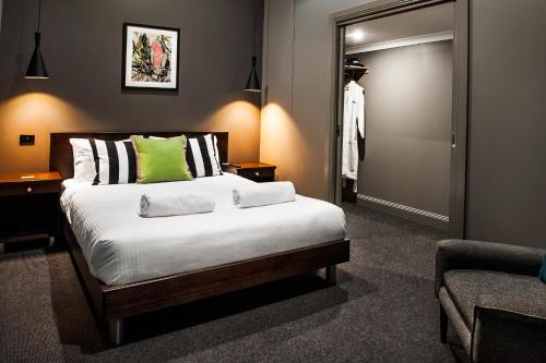 a bedroom with a large bed and a mirror at Criterion Hotel Sale in Sale