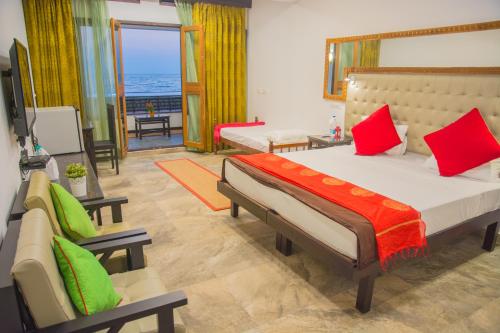 a bedroom with a large bed and a living room at 36 Palms Residency - Sea View Villa in Cochin