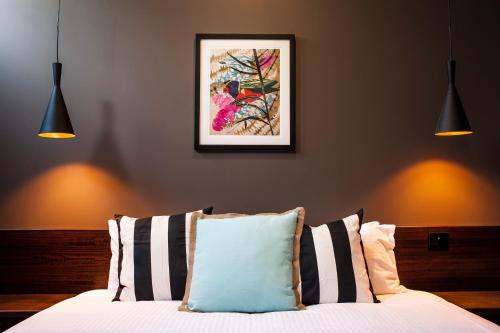 a bedroom with a bed with two lights on the wall at Criterion Hotel Sale in Sale