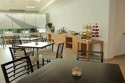 a dining room with tables and chairs and a kitchen at Costa Bahia Hotel, Convention Center and Casino in Guayanilla