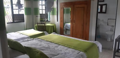 a bedroom with two beds and a bathroom at Kandy Holiday Home in Kandy
