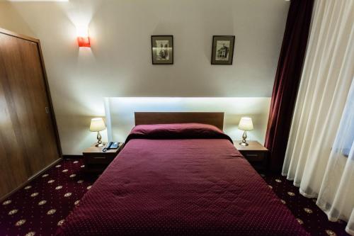 a bedroom with a large red bed with two lamps at Hotel Ferdinand in Constanţa