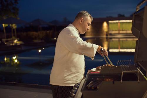 a man cooking food on top of a grill at Emerald Palace Hotel in Nay Pyi Taw