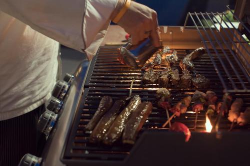 a person is cooking food on a grill at Emerald Palace Hotel in Nay Pyi Taw