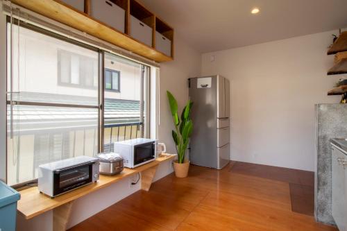 a kitchen with a desk with a microwave and a refrigerator at CRAFT in Matsubara