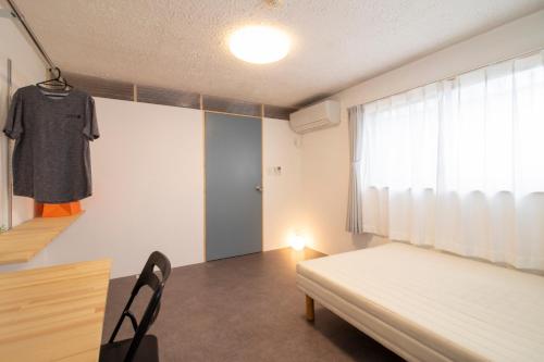 a bedroom with a bed and a shirt hanging in a window at CRAFT in Matsubara