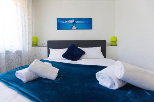 a bedroom with a bed with blue sheets and pillows at Hotel Berlin in Schwetzingen
