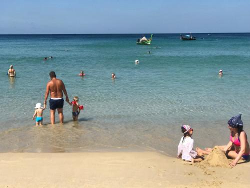 a group of people playing in the water at the beach at KARON SINO House in Karon Beach