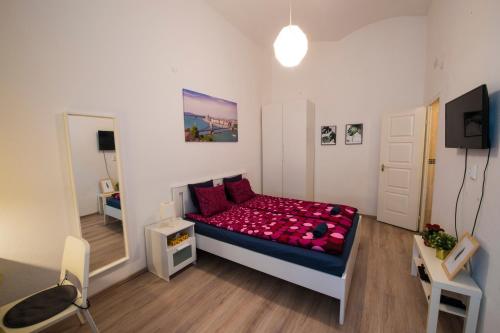 ブダペストにあるNo. 11 Apartment with 2 bathrooms next to railway stationのベッドルーム1室(赤い枕のベッド1台付)