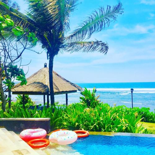 a resort swimming pool with a view of the ocean at Anapuri Villas in Ketewel