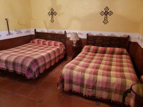 two beds sitting in a room with at Ex-Hacienda San Buenaventura in San Lorenzo Soltepec