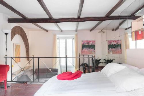 a bedroom with a white bed with a red hat on it at Cedro Terrace&Jacuzzi - Loft in Trastevere in Rome