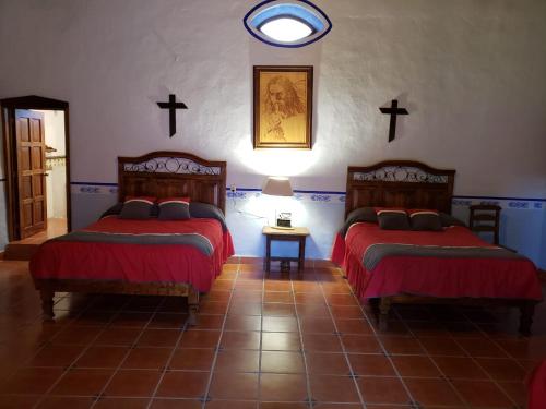 two beds in a room with crosses on the wall at Ex-Hacienda San Buenaventura in San Lorenzo Soltepec