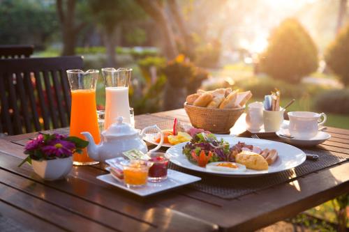 a table with a breakfast of eggs and food on it at The Imperial River House Resort, Chiang Rai in Chiang Rai