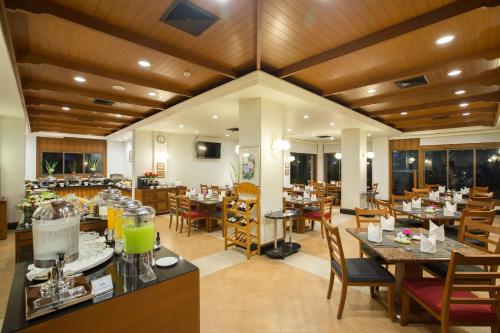 a restaurant with wooden ceilings and tables and chairs at The Imperial River House Resort, Chiang Rai in Chiang Rai