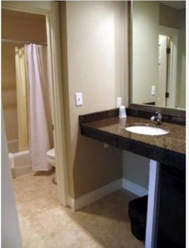 a bathroom with a sink and a toilet and a shower at Magnolia Beach Inn - Fairhope in Fairhope