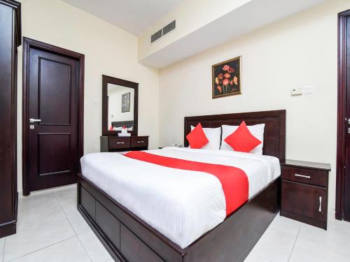 a bedroom with a large bed with red pillows at Paradise Inn 1 Tabasum Group in Ajman 