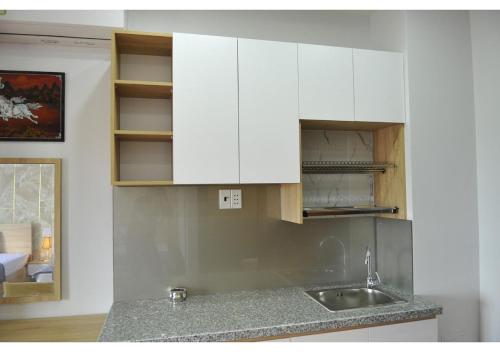 a kitchen with white cabinets and a sink at Cherry Hotel Bến Lức in Bến Lức