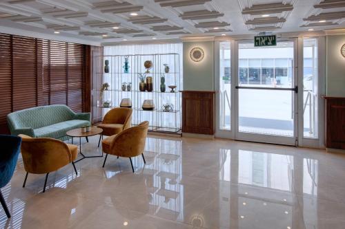 a lobby with chairs and a table in a building at Armon Hayarkon Hotel in Tel Aviv