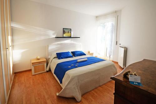 ヴァストにあるAppartamento Il Faro - MyHo Casaのベッドルーム1室(青いシーツと窓付)