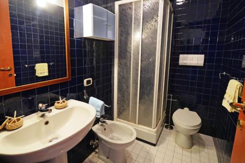 ヴァストにあるAppartamento Il Faro - MyHo Casaの青いタイル張りのバスルーム(洗面台、トイレ付)