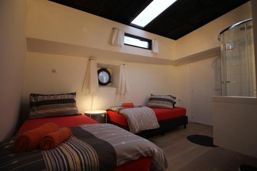 two beds in a small room with a window at Nachtwacht Apartment in Amsterdam
