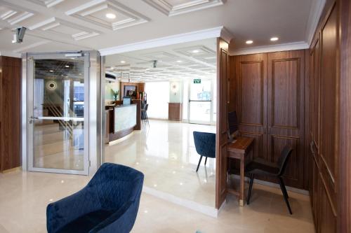 a lobby with blue chairs and a table and a counter at Armon Hayarkon Hotel in Tel Aviv