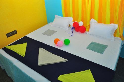 a bed with colorful pillows and balloons on it at Royal Homestay New Hampi in Hampi