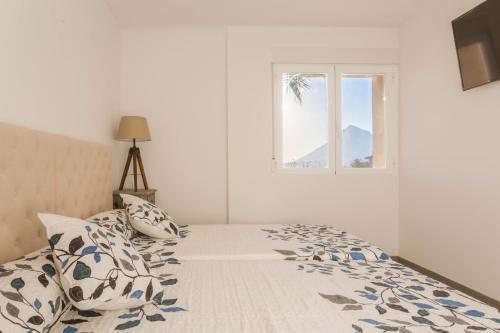 ハベアにあるApartamento Urbatenisの白いベッドルーム(ベッド1台、窓付)