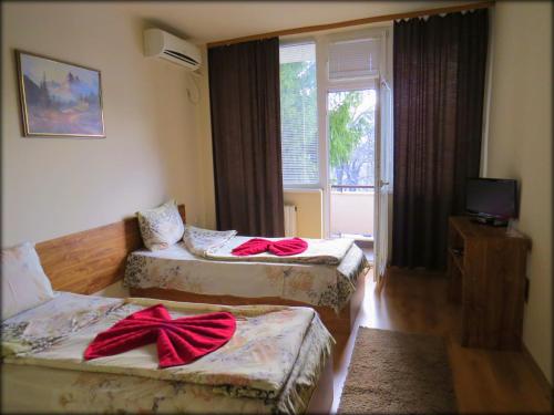 a room with three beds with red bows on them at Туристически дом Кайлъка in Pleven
