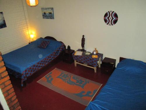 a bedroom with two beds and a table and a table at Isange Paradise Resort in Ruhengeri