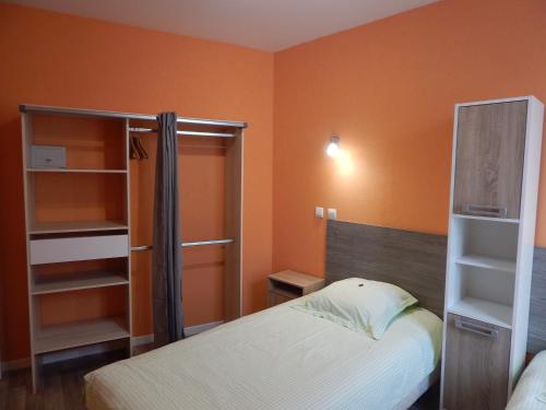 a bedroom with two beds and an orange wall at Le Lion D'or in Ouroux en Morvan