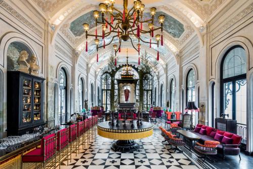 a large room with a large chandelier and red chairs at Hotel de la Coupole - MGallery in Sa Pa