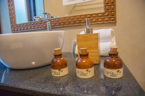 three bottles of honey on a counter next to a sink at 36 Palms Residency - Sea View Villa in Cochin