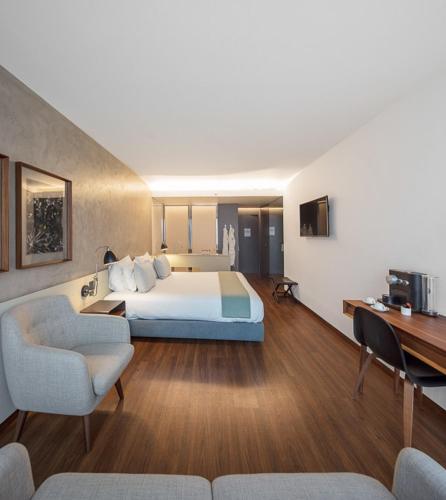a hotel room with a bed and a desk at Lux Lisboa Park in Lisbon