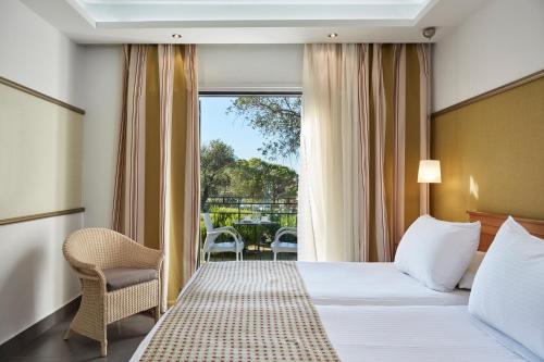 um quarto de hotel com uma cama e uma varanda em SENTIDO Apollo Palace em Mesongi