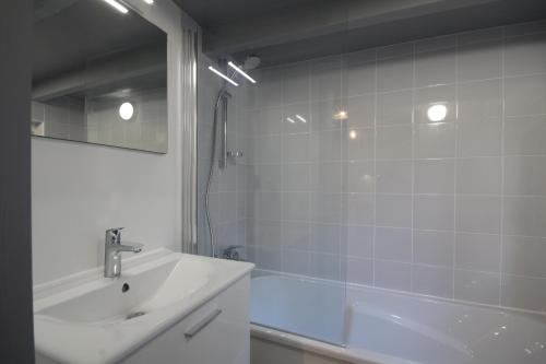 ein Bad mit einer Badewanne, einem Waschbecken und einer Dusche in der Unterkunft Entre Mer et Golf in Étretat