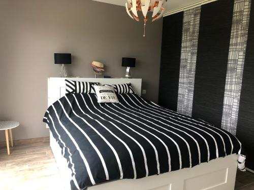 una camera da letto con letto a righe bianche e nere di lily's rooms a Mulsanne